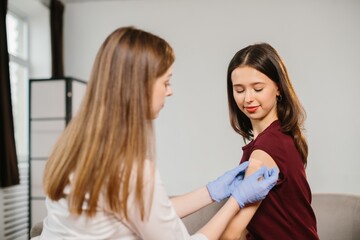 Healthcare worker applying bandage after vaccination injection