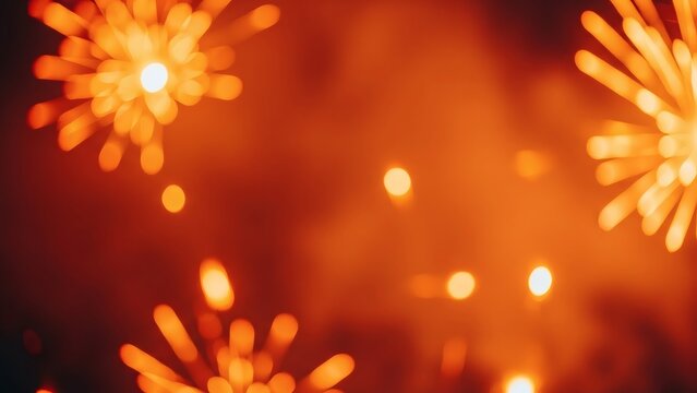 Abstract defocused bright sparks of fireworks in a warm orange and red glowing bokeh background