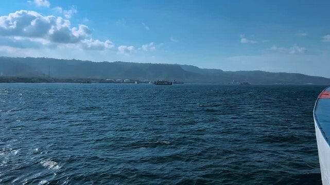 Bali, Indonesia - August 27, 2025: Car and passenger ferries cross the Bali Strait from Gilimanuk Harbor to Ketapang Harbor. View of the strait from the ferry deck. 4К