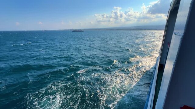 Bali, Indonesia - August 27, 2025: Car and passenger ferries cross the Bali Strait from Gilimanuk Harbor to Ketapang Harbor. View of the strait from the ferry deck. 4К
