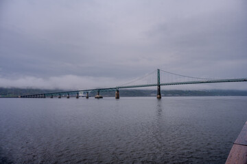 Suspension bridge spanning the Saint Lawrence River on a cloudy day