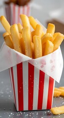 Golden French Fries in a Red and White Striped Container.