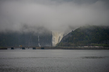 Waterfall in fog behind bridge over Saint Lawrence River