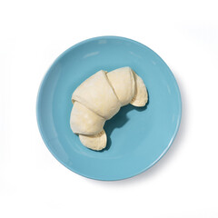 Top view of a frozen croissant on a light blue plate, minimal food composition highlighting pastry texture, bakery product, breakfast concept, and cold storage convenience.