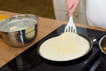 Hobbykoch dreht Palatschinke mit Pfannenwender