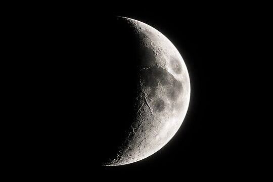 Close-up of the waning gibbous moon in a dark night sky, revealing surface details. - Powered by Adobe