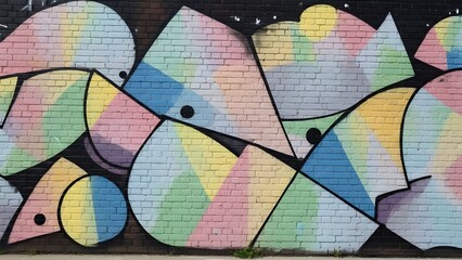 A vibrant and dynamic street art mural featuring an abstract composition of pastel-colored geometric shapes and bold black outlines on a brick wall, creating a modern urban backdrop.