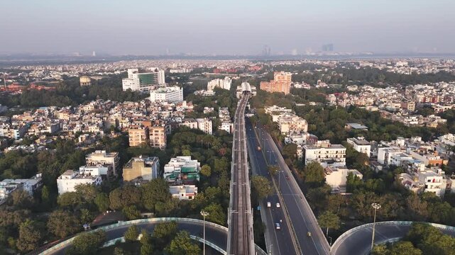 An aerial view of Sukhdev Vihar Metro Station and Modi Mill Flyover cutting through South Delhi&rsquo;s green canopy, where modern transit weaves seamlessly between residential blocks and urban landscapes.