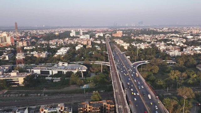 A wide drone shot of Delhi&rsquo;s Sukhdev Vihar Metro Station, highlighting the city&rsquo;s expanding transit network amid tree-lined roads, residential clusters, and the distant skyline.