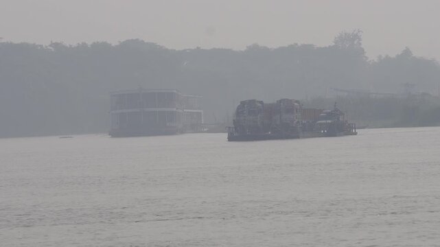 large hovercraft or air-cushion vehicle, moving across a body of water in hazy conditions