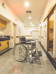 Empty wheelchair in a modern hospital corridor with clean interior and bright lighting. Healthcare and medical concept representing patient care, disability support, rehabilitation, emergency services