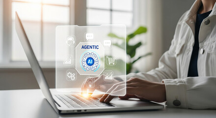 Person interacting with Agentic AI interface on laptop, featuring chatbot, analytics, shopping cart, and user icons, representing artificial intelligence in modern digital business platforms.
