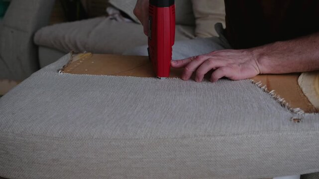 Furniture Upholstery with Electric Staple Gun, Craftsman Hands Close Up