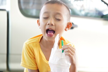 Happy Young Boy Enjoying a Refreshing Drink with Eyes Closed and Excited Expression in Urban...