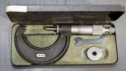 A used micrometer in its storage box, a precision measuring instrument for professional use in the mechanical industry and mechanical maintenance