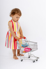 Cute Toddler Girl Playing with Toy Shopping Cart. Happy Childhood.  Playful childhood fun