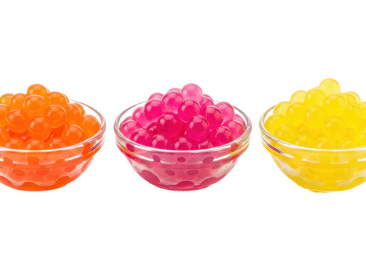 Extreme macro close-up of three bowls containing vibrant orange, pink, and yellow hydrocolloid popping boba pearls on a transparent studio background, concept of molecular gastronomy