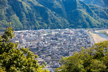 緑の山々と川に囲まれた岡山県高梁市の地方都市の俯瞰風景