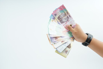 Hand holding Indonesian rupiah banknote on white background representing cash payment, personal...