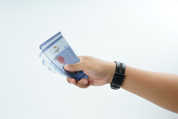Fototapeta premium Hand holding Malaysian ringgit banknote on white background representing cash payment, personal finance, income, and financial transaction with clean minimal composition.
