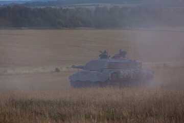Challenger 2 tank at sunset, Image shows a single main battle tank or FV4034 moving across the plain a sunset generating a dust cloud