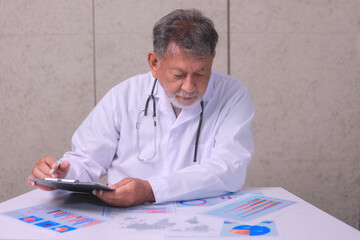 Focused senior doctor doing medical management review ensuring data privacy standards