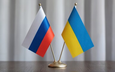 Two distinct national flags Russia with white blue red stripes and Ukraine with bright blue yellow bands stand side by side on a shiny gold display holder on a dark wooden surface A softly lit neutral