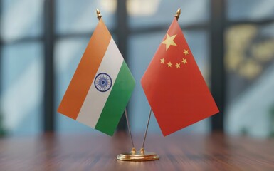 The national flags of India and China are displayed side by side on a polished wooden table in a professional indoor setting Soft natural light illuminates the vibrant colors of both flags symbolizing