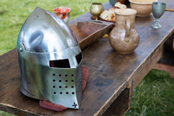 Medieval knight's helmet on the edge of a wooden table