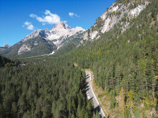 Mountain Road - Dolomites National Park Italy - Alpine landscape with mountains and pine trees in autumn fall summer - panoramic aerial view