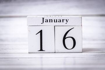 Wooden calendar displaying the date January 16 against a rustic wooden background. The calendar...