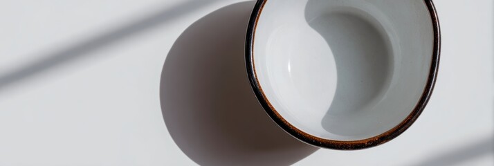 白い皿の上に置かれたカップと影の様子