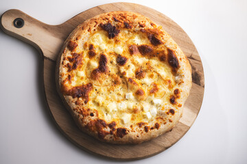 Tasty four cheese pizza in close-up baked to perfection on a wooden board. View from above.