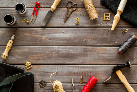 Frame flat lay of leather craftsman or shoemaker tools and equipment, top view