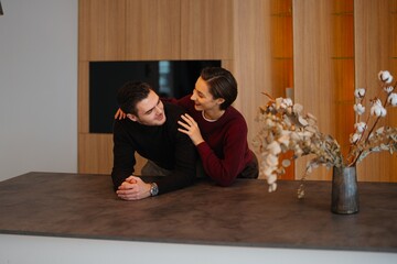 Couple enjoying intimate moment in modern kitchen during winter afternoon
