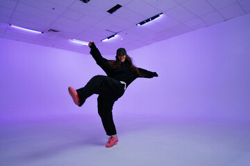 Energetic dancer showcases stylish moves in vibrant studio setting