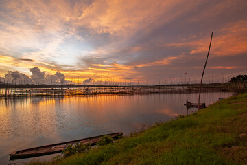 Golden Sunset Over Calm Lake with Fishing Nets and Reflections at Dusk