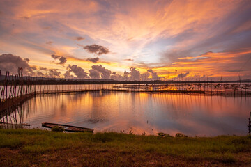 Golden Sunset Over Calm Lake with Fishing Nets and Reflections at Dusk