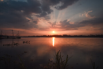 Golden Sunset Over Calm Lake with Fishing Nets and Reflections at Dusk