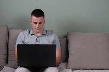 serious adult man working from home on his laptop, home office