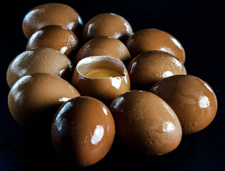 View of Egg yolk in Broken raw chicken eggshell in the among of Fresh chicken egg (Hen egg) on dark background. Natural organic fresh eggs for healthy food, use it as your Wallpaper, Poster, Design