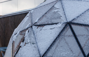 Geodesic glass dome covered with snow in winter