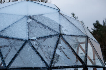 Geodesic glass dome covered with snow in winter