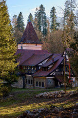 Fototapeta premium Charming timber-framed house with red roof in forest setting