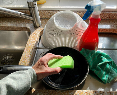 Fregando sart&eacute;n con estropajo de esponja