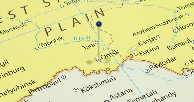 A zoom out of a blue pin into omsk city of russia political map