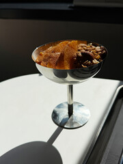 Breakfast yogurt parfait with granola, fresh peaches and cinnamon topping. Healthy food idea. Manual mobile photography, selective focus, bright direct sunlight, no AI