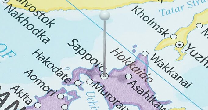 A zoom out of a white pin into sapporo city of japan political map