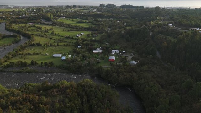 Aerial Side View of Serpentine River Valley Hamlet and Bay