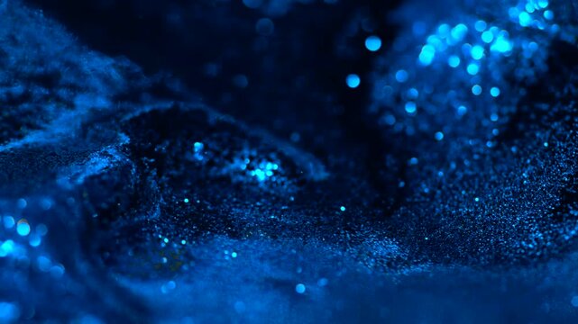 Blue liquid abstract glitter particles flowing on a dark macro surface, creating a smooth cinematic depth effect perfect for visual design, overlays, luxury backgrounds and motion projects.